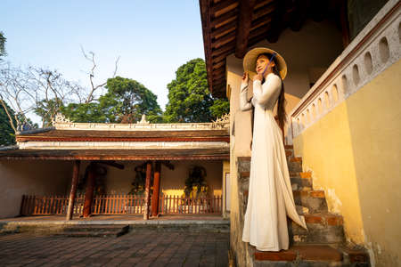 Hue City, Thua Thien Hue Province, Vietnam - May 7, 2020: A scene of a girl in a traditional ao dai costume praying inside a templeのeditorial素材