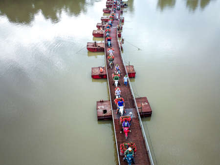 Tong Lenh floating Bridge, Luc Ngan District, Bac Giang Province, Vietnam - July 11, 2020: Farmers harvest litchi fruits and transport them by motorbike for sale. Photos viewed from aboveのeditorial素材