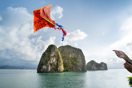 Ha Long Bay, Quang Ninh Province, Vietnam - July 3, 2020: Female tourist excited with colorful kite on the deck. Beautiful scenery of Ha Long Bay. North Vietnamのeditorial素材