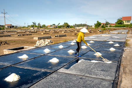 Nghe An province, Vietnam - July 30, 2020: Image of a woman making salt in Nghe An province, Vietnamのeditorial素材