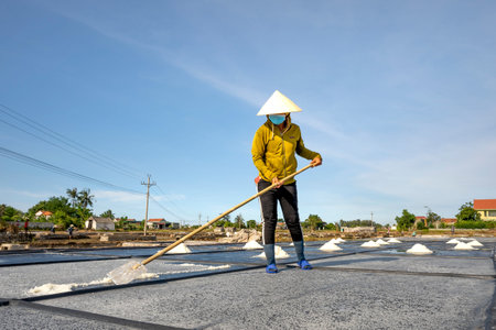 Nghe An province, Vietnam - July 30, 2020: Image of a woman making salt in Nghe An province, Vietnam
