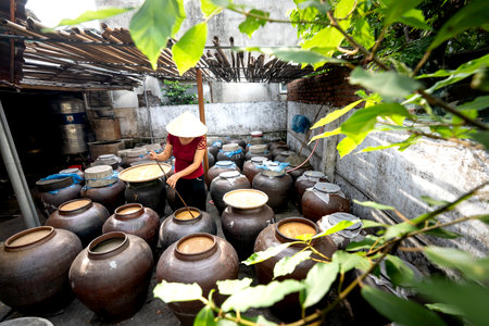 Nghe An Province, Vietnam - July 31, 2020: A woman works at a traditional "soy sauce" food production facility in Nghe An province, Vietnam. Soy sauce is fermented from soybeansのeditorial素材