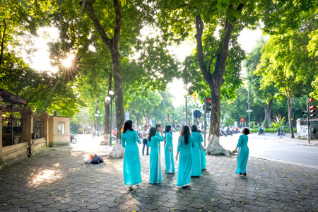 Women dressed in national costume,aoi dai,during Tet, Lunar New Year in central Hanoi, Vietnam, Asia.のeditorial素材