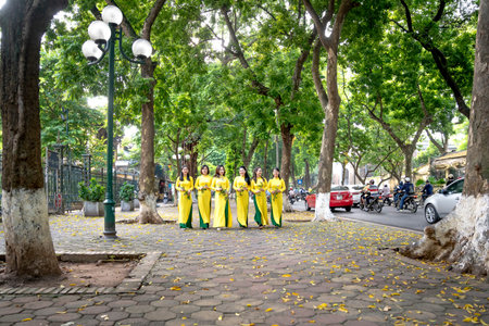 Women dressed in national costume,aoi dai,during Tet, Lunar New Year in central Hanoi, Vietnam, Asia.のeditorial素材