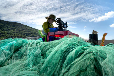 Vinh Hy Bay, Ninh Thuan Province, Vietnam - January 17, 2021: Vietnamese woman working as a net mending worker in Vinh Hy Bay, Ninh Thuan Province, Vietnamのeditorial素材