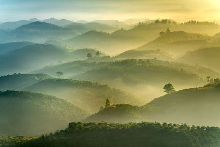 Fanciful scenery of an early morning when the sun rises over the Dai Lao mountain range, Bao Loc district, Lam Dong province, Vietnamの写真素材