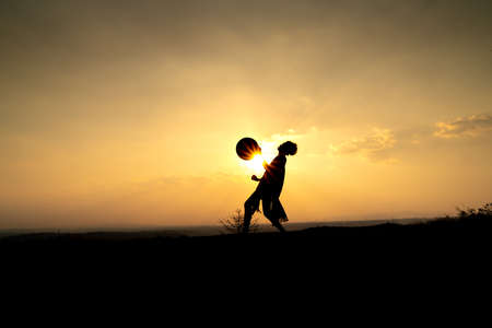 Pleiku Town, Gia Lai Province, Vietnam - March 6, 2021: Ede boys and girls perform their traditional dance during their sunset period in Pleiku town, Gia Lai province, Vietnam. Silhouette.