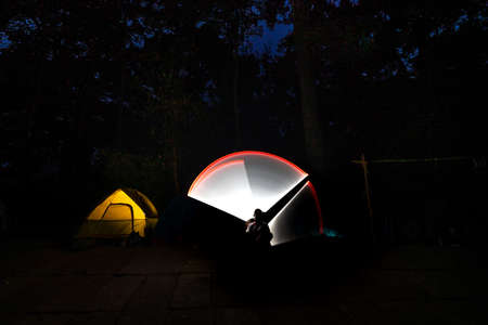 K 'Bang District, Gia Lai Province, Vietnam - March 8, 2021: Tourists photographed light painting next to a camping tent in the jungle in K' Bang district, Gia Lai province, Vietnamのeditorial素材