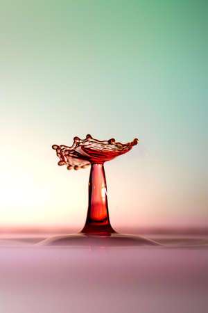 Moment of water drops colliding on pink background. Abstract natural backgroundの写真素材