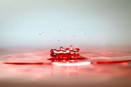 Moment of water drops colliding on pink background. Abstract natural backgroundの写真素材