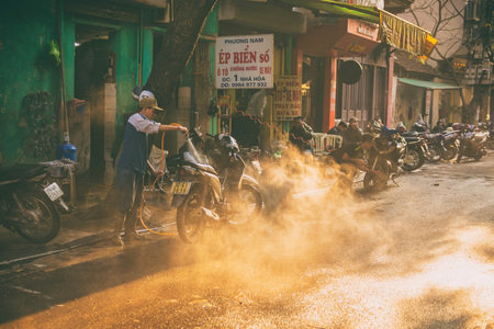Hanoi, Vietnam - January 13, 2015 - The man washing the motorcycle in the afternoon dayのeditorial素材