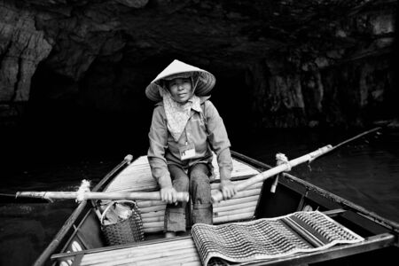 Ninh Binh, Vietnam - 02 June, 2013: The woman drive the boat in the riverのeditorial素材