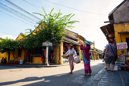 Hoi An, Vietnam - September 02, 2013: The tourist is taking photos in the street while the vendor is walking acrossのeditorial素材