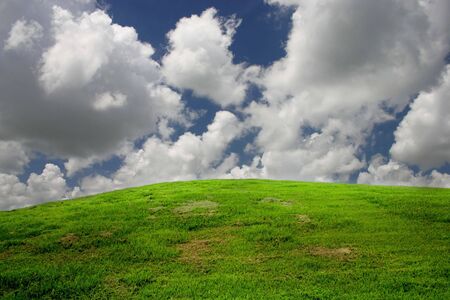 clouds passing over a green hillの写真素材