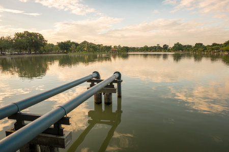 Steel pipe connect from pump into the lake within public parkの写真素材