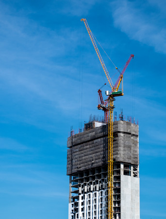 Industrial construction crane for high rise building with blue sky backgroundの写真素材