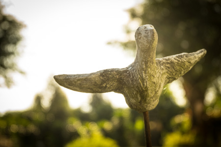Ceramic flying bird with flare effect on blurred background, soft and selective focus.の写真素材