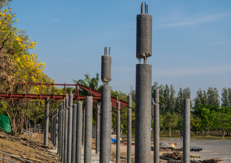 Construction method of connection on top of round concrete column with blue sky background.