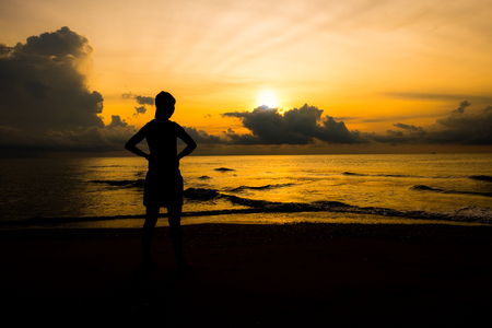 Silhouette of young sport women looking up sunrise or sunset at the beach that meaning the power of life and positive thinking.の写真素材