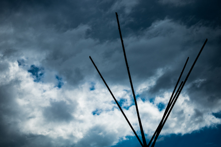 The top of the teepee tent symbol of outdoor activities in silhouette mood and tone with most cloudy sky background, selective focus.の写真素材