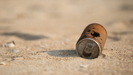 Old rusty can dropped on the sand beach, environmental problems and global warming.の写真素材