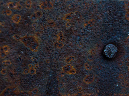 rusty metal sheet with a nail, grunge backgroundの写真素材