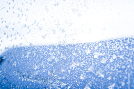 blue and white winter background with snowflakes under the sun