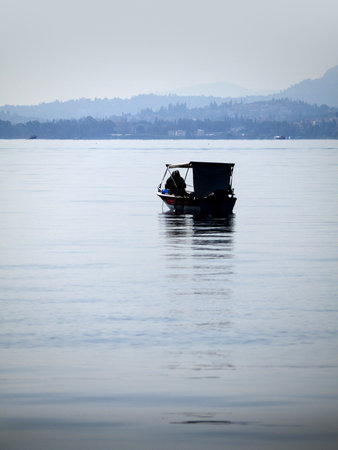 Lone Fisherman on quiet sea around Island of Corfu Greece