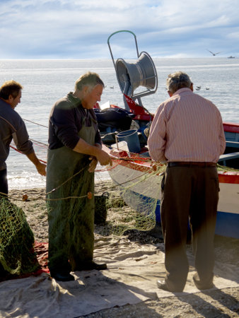 Fishermen sorting out their nets on the Burriana Beach in Nerja Spainのeditorial素材