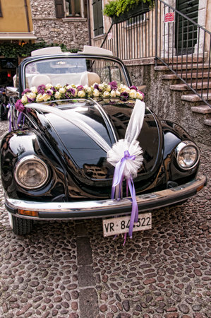 Malcesine is one of the lovely towns on this lake in Northern Italy  It has its own castle guarding the town popular now for weddings  The narrow streets mean wedding cars must be small, so this VW is perfectのeditorial素材