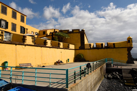The ancient yellow Fortress of Sao Tiago with its bathing platforms into the Atlantic Oceanのeditorial素材