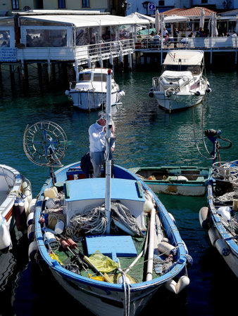 Fishing boat in  the original fishing harbour of Marina Grande in Sorrento a small city in Campania, Italy.  It is a busy fishing port supplying the town and a popular European tourist destination. Vesuvius is in the distanceのeditorial素材