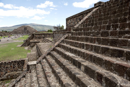 pyramids on the avenue of the dead in Teotihuacan, Mexico, with stone stairs in the foreground and the pyramid of the Moon in the backgroundの写真素材
