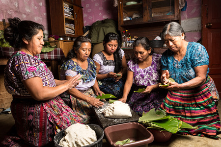 January 20, 2015, San Pedro la Laguna, Guatemala: traditionally dressed mayan tzutujil women preparing specific local food on the house floorのeditorial素材