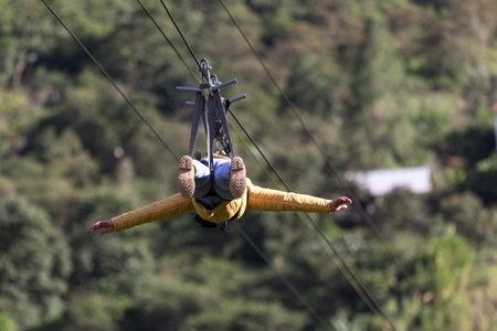 July 15, 2016 Banos, Ecuador: a man slides head first on zipline across a canyon