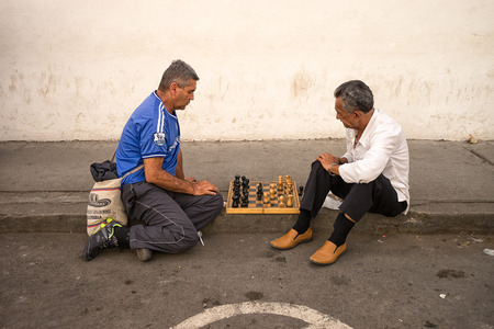 July 6, 2017 Popayan, Colombia: men playing chess sitting on the sidewalk in the Southern colonial townのeditorial素材