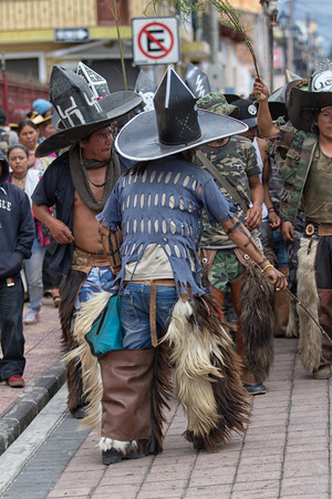 June 29, 2017 Cotacachi, Ecuador: kichwa indigenous people with extra large hats and chaps dancing on the street during Inti Raymi festivalのeditorial素材