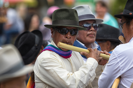 June 29, 2017 Cotacachi, Ecuador: indigenous kichwa man playing a flute made of bamboo during summer solstice celebrationsのeditorial素材