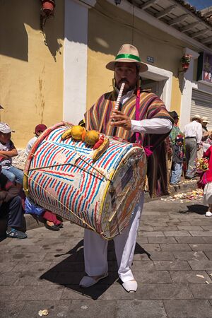 June 17, 2017 Pujili, Ecuador: indigenous quechua male drumming and playing the flute in the same time setting the rhytm for the Corpus Christi parade dancersのeditorial素材