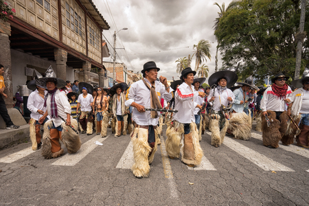 June 24, 2017 Cotacachi, Ecuador:  indigenous kichwa men wearing chaps dancing at the Inti Raymi parade at summer solsticeのeditorial素材
