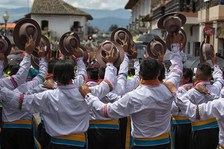 June 17, 2017 Pujili, Ecuador: male dancers hoding their hats in the air at Corpus Christi festivalのeditorial素材