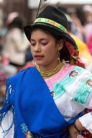 June 17, 2017 Pujili, Ecuador: young indigenous woman in bright color traditional clothing at Corpus Christi parade dancing in the streetのeditorial素材