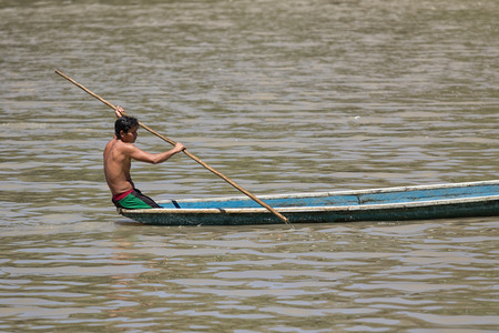 June 6, 2017 Misahualli, Ecuador:  indigenous man in canoe on the Napo river in the Amazon areaのeditorial素材