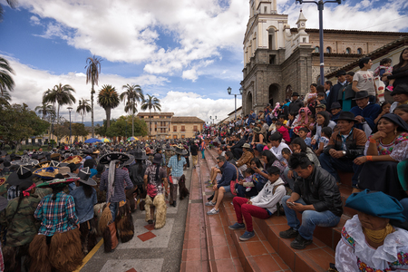 June 25, 2017 Cotacachi, Ecuador: spectators stting on the stairs of the church in the main plaza watching the Inti Raymi paradeのeditorial素材