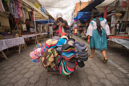 April 29, 2017 Otavalo, Ecuador: mobile vendor selling hats from a cart in the Saturday marketのeditorial素材