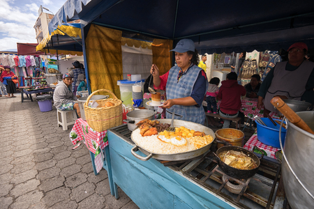 April 29, 2017 Otavalo, Ecuador: indigenous quechua women are preparing food on the street in the Saturday marketのeditorial素材