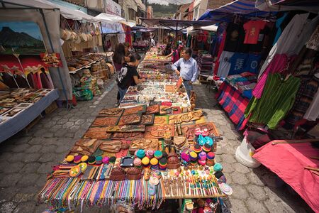 April 29, 2017 Otavalo, Ecuador: indigenous quechua people selling artisan gifts on stands set up on the street in the Saturday marketのeditorial素材