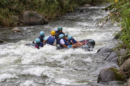 February 28, 2017 Mindo, Ecuador: tourists wearing helmet tubing on the Mindo Riverのeditorial素材