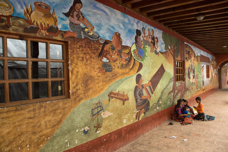 February 5, 2015 Chichicastenango, Guatemala: indigenous people sitting in the shade of a colourful colonial buildingのeditorial素材