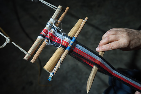 April 27, 2016 San Pedro la Laguna, Guatemala: closeup of maya woman's nad using traditional tools for weavingのeditorial素材